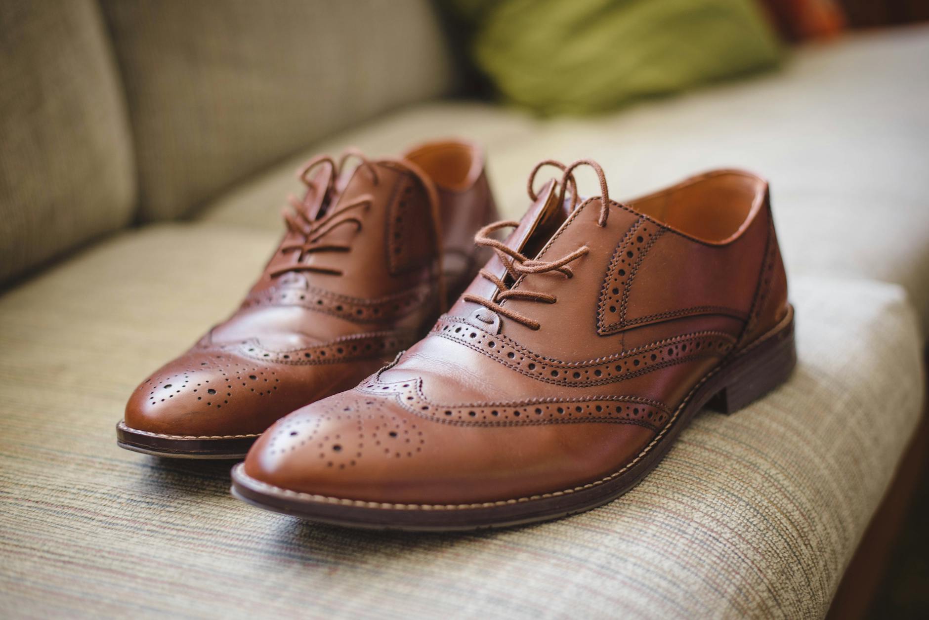 Eleganckie brązowe skórzane buty męskie na szarej powierzchni