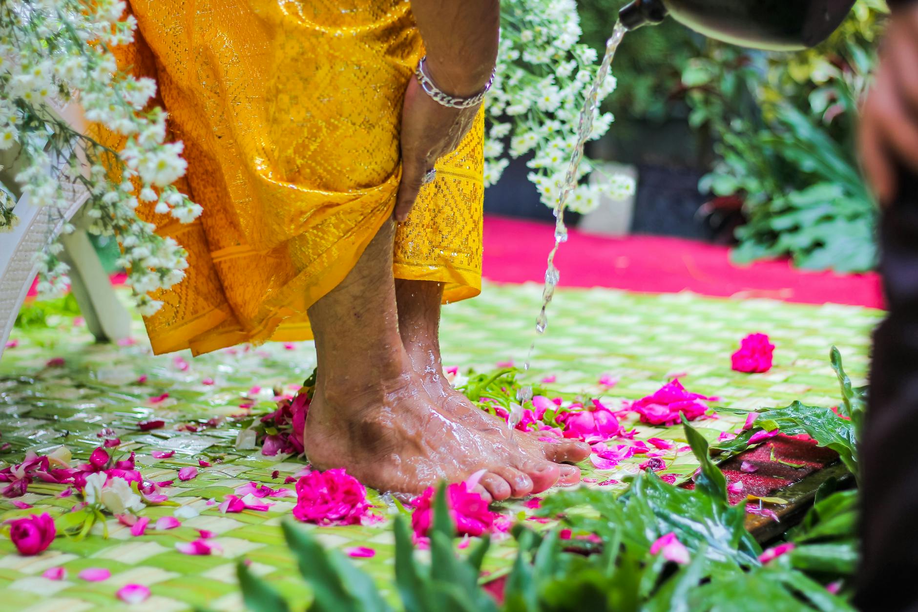 Ceremonialne obmywanie bosych stóp wodą z płatkami kwiatów