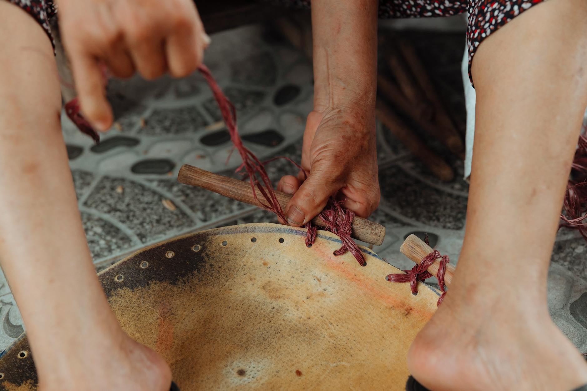 Ręce rzemieślnika przy pracy nad tradycyjnym bębnem