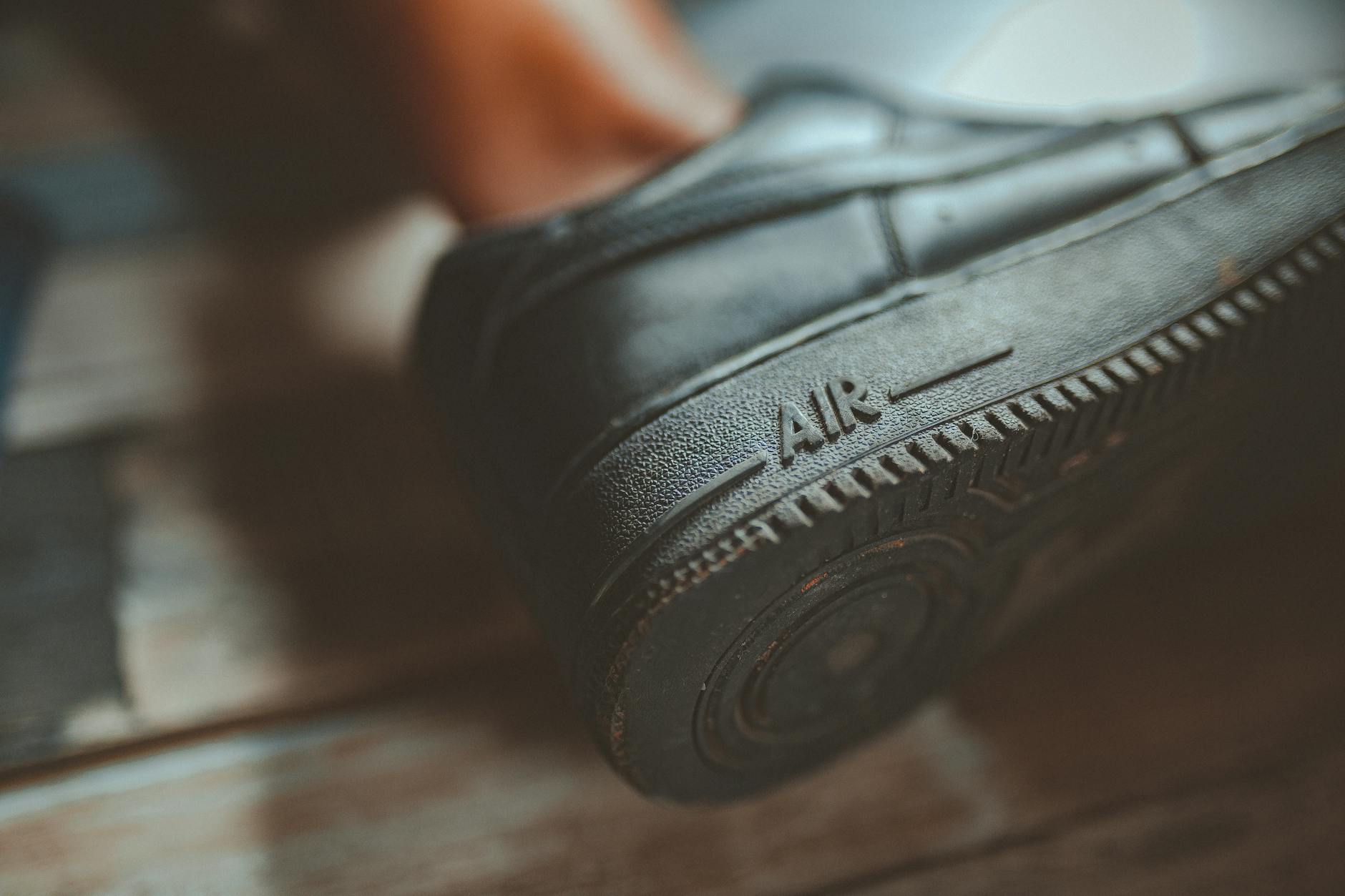 Zbliżenie podeszwy czarnego trampka z napisem Air i fakturą gumy
